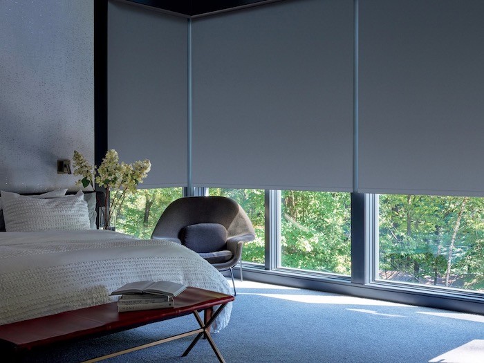 A bedroom with a reading nook in the corner.